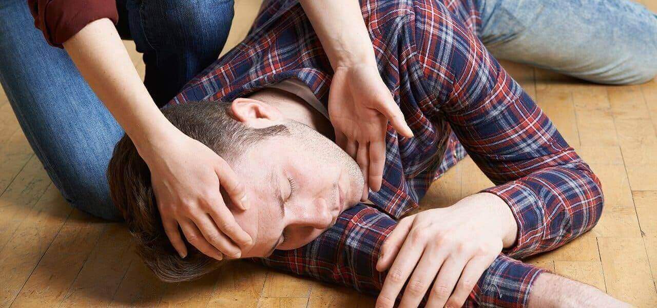 Человек без сознания лежит на боку
